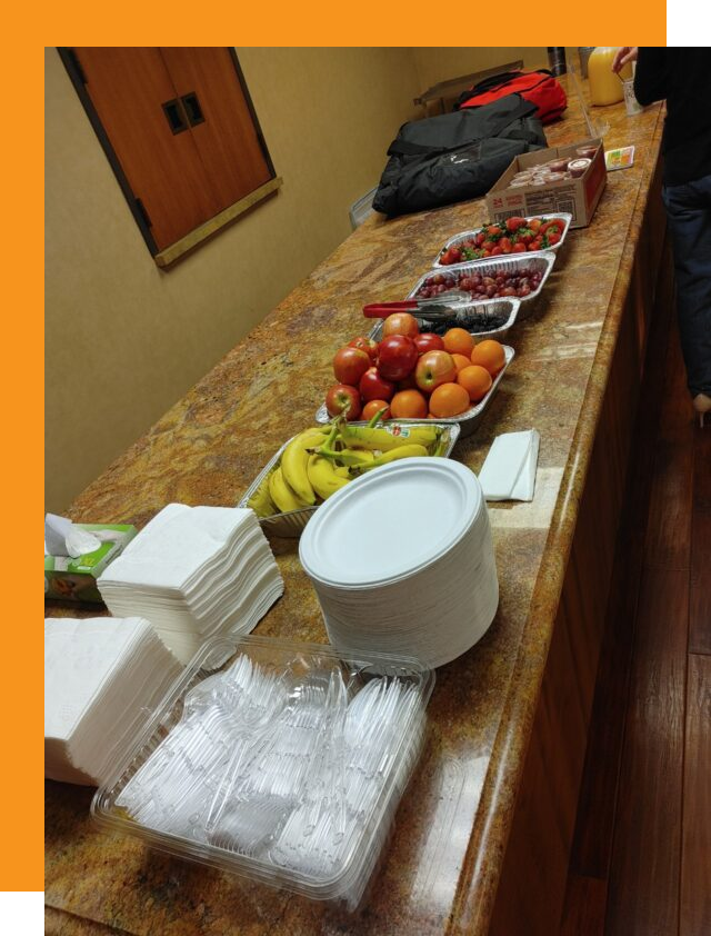 A catering counter with a lot of fruit on it.