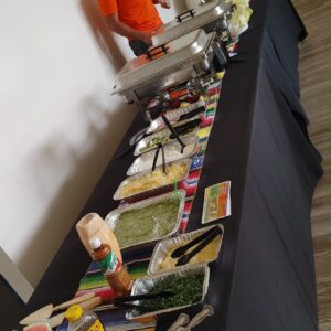 A man is catering food on a table in front of a buffet.