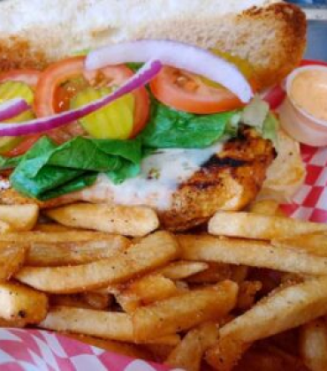 A chicken sandwich and french fries in a basket.