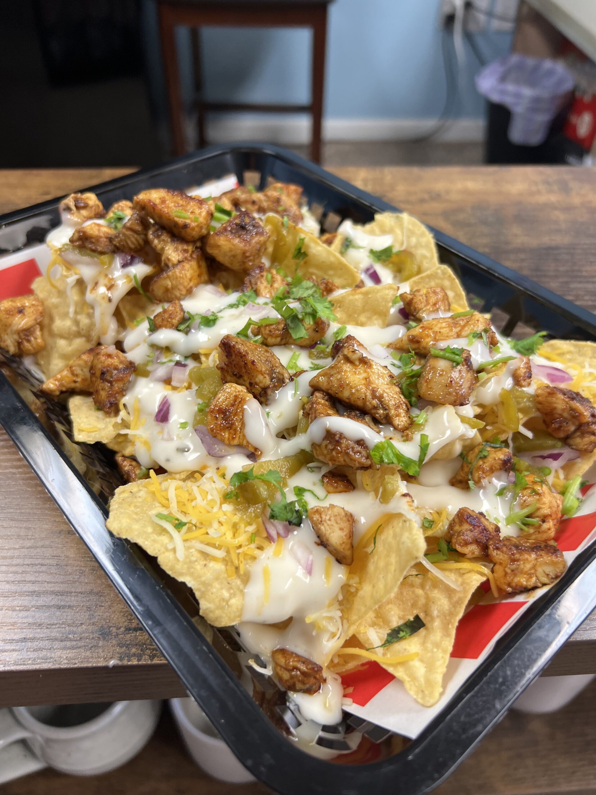 Flavorful chicken nachos on a tray on a table at Flavor on 35.